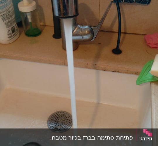 ברז מטבח עם מים זורמים לכיור